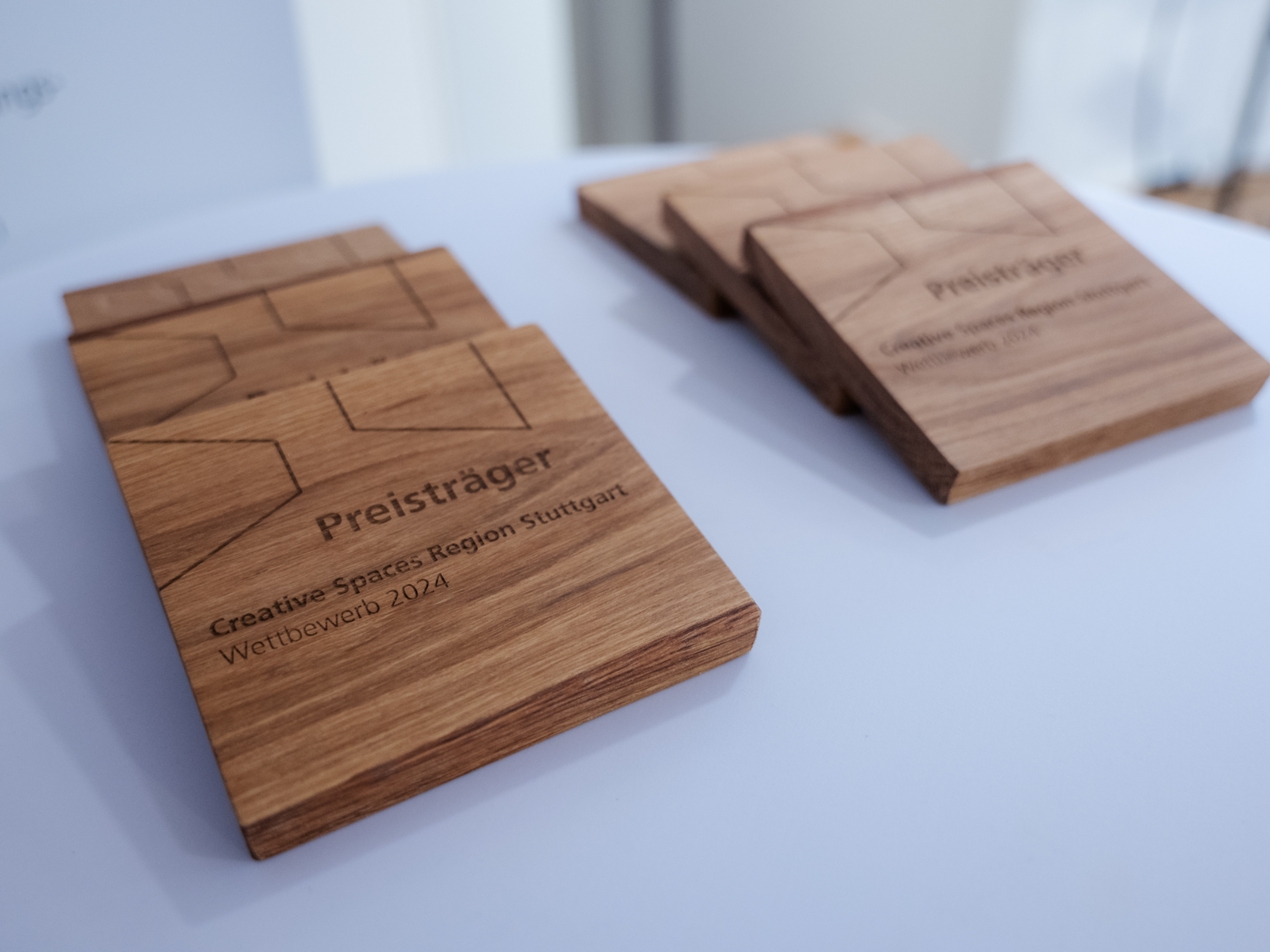 Holzplaketten mit Gravur "Preisträger" für den Wettbewerb "Creative Spaces Region Stuttgart 2024".