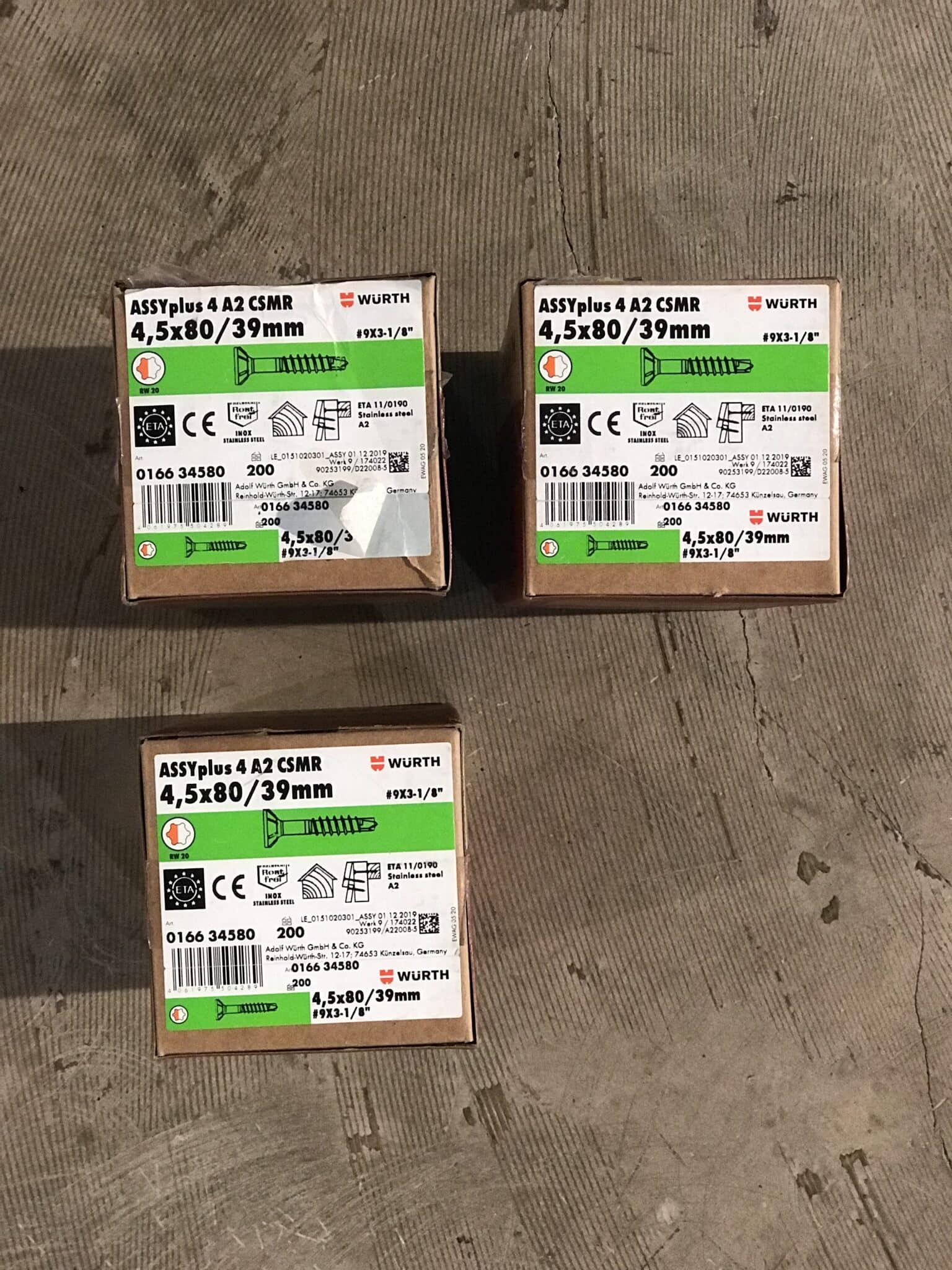Drei Kartons mit ASSYplus A2 CSMR Schrauben 4,5x80/39mm von Würth, mit Versandetiketten und technischen Informationen.